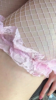 Schlanke Schönheit mit großen, natürlichen in rosa Netzstrümpfen neckt saftigen Hintern