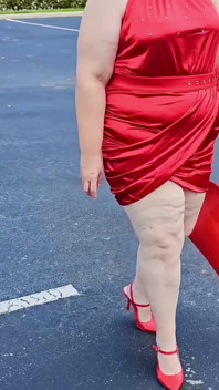 Wanita cantik berjalan di luar rumah di tempat letak kereta menunjuk-nunjuk untuk orang asing