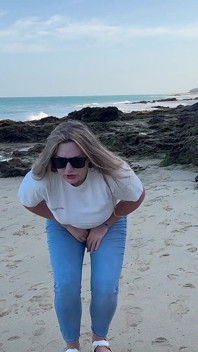 Plassen in een strakke spijkerbroek op het strand
