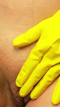 La sorellastra gigantessa mette il fratellastro nel suo guanto giallo per lavare i piatti e poi gioca con lui divertendosi con lui