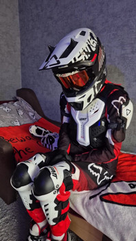 Seorang lelaki yang teruja dalam gear motosikal mengongkek si kasutnya