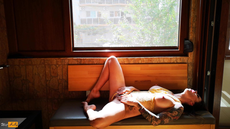 Wet Kelly: Napalona milf bawi się obok okna