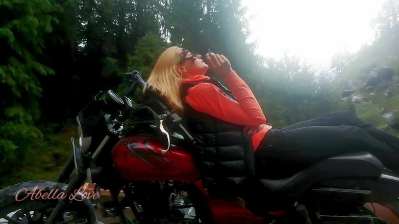 Abella Love: Red lips blonde smoking sensually on Rasta bike outdoor