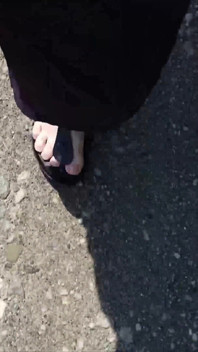 กลางแจ้งในชุดคาฟตันสีดําและเท้าเปล่าในรองเท้า Birkenstocks สีดํา
