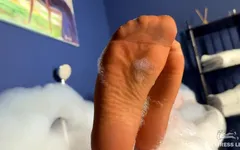 La dea fa un bagno in collant marrone chiaro e ti stuzzica con i piedi in nylon