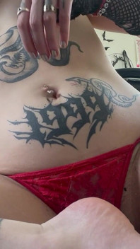 Goth dívka si prstí břicho a hraje si s piercingem na pupek