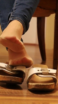 Tentación colgante - espadrilles y sandalias de madera jugando con los pies