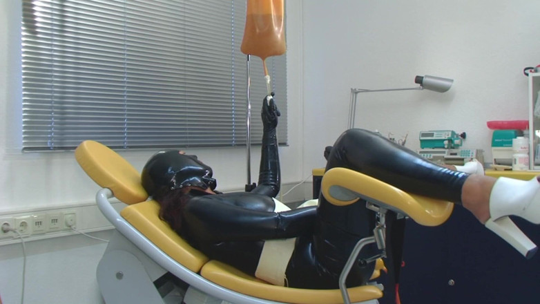 Rubber & Clinic Studio - 1ATOYS: Enema dalam lateks catsuit