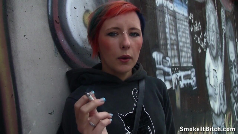 Smoke it bitch: Une fille aux cheveux colorés et un visage percé fume...