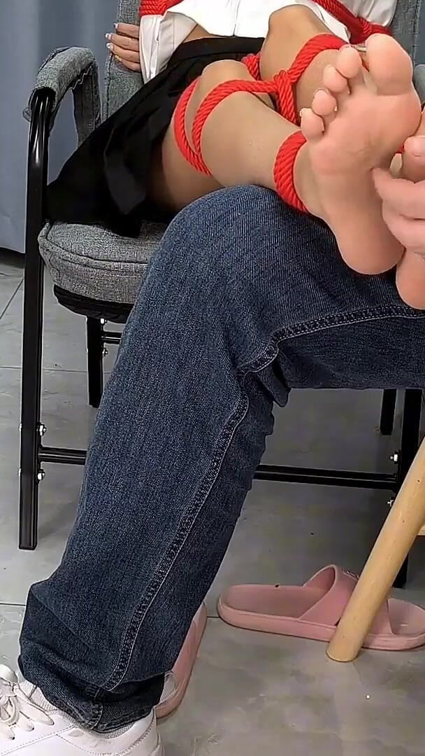 Asian bondage: La chica descalza está atada con cuerdas rojas, cosquillas en...