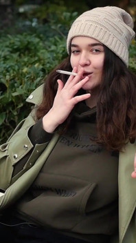 Młoda brunetka bierze niespieszny spacer z Allwhite 120mm papierosem