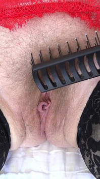 La chatte poilue mature éjacule du peigne en gros plan. Fétichisme amateur avec un pubis potelé et un buisson.