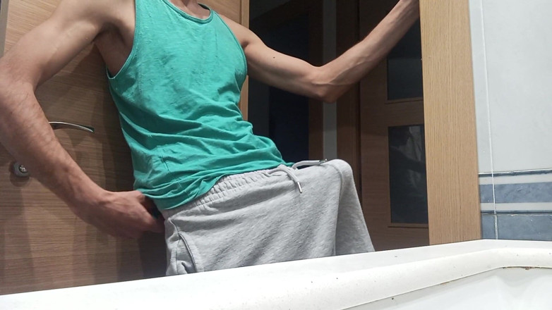 Elvissc: Schlanker typ in einem tank-top zeigt, wie er mit seinem...
