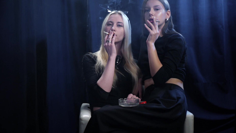 Russian Smokers: 柔らかな青い照明の下、暗いスタジオで一緒にタバコを吸う二人の女性