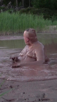 Kąpiel błotna w głębokim stawie błotnym w żwirniku