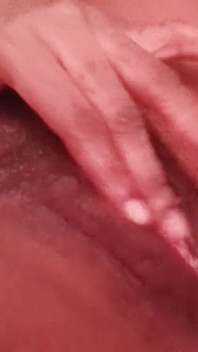 Acostado en la cama con piernas abiertas frotando mi peludo y apretado coño