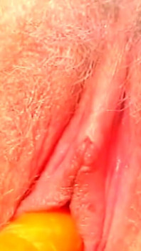ブロンドの美女が野外でニンジンで膣を詰め込む