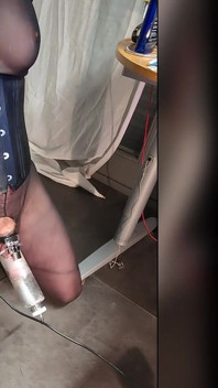 Domina controla loira em botas pretas, espartilho, meias, frogtied com uma gaiola de ordenha para extrair porra