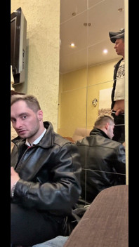 Um pidr de terno serve a um gopnik de tênis esportivos e jaqueta de couro