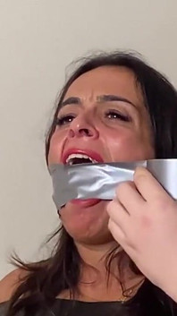 Latina strak vastgeplakt en mond gesnoerd met een grote balgag en vervolgens met grote tape wrap gag! (kleiner formaat)