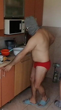 Koppel plezier in de keuken. Sexy vrouw doet naakt klusjes in het huis