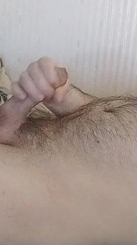 침대에서 자위하고 털이 무성한 배에 사정하는 통통한 게이