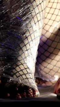 Gambe bendate: provocazione con pellicola trasparente e feticismo per i piedi.