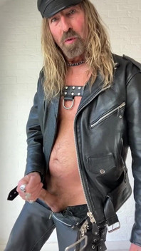 Longhairdude in volledig leer trekt af en snijdt