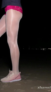 Anna in collant bianchi lucidi sulla spiaggia di notte