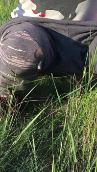 草原の草むらでおしっこをする