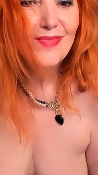 Rijpe roodharige dame 50+ striptease in transparante smaragdgroene jurk