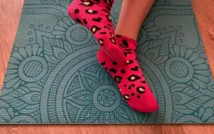 Athletic Girl Doing Leg Exercises in Pink Socks on a Yoga Mat