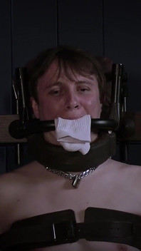 Ricky dans une chaise bondage, bâillon en acier et rembourrage en chaussettes.