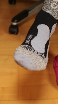 Retrait des chaussettes et jeu de chaussures de sabot sous le bureau - legging gris, sabots roses et bas nylon