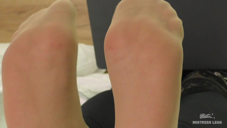 Mistress Legs: Meesteres voeten in zachte nylon sokken rusten op het bed