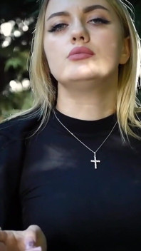 热辣的金发女郎在大自然中抽两支黑色香烟