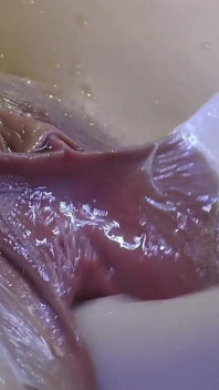 Çok yakından dildo ve camla geniş yayılmış vaginasını sevişmek