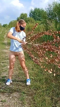 O fată fără fund cu cozi merge de-a lungul unui drum de țară
