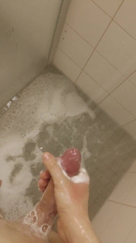 Branco jovem garoto magro sob o chuveiro mijo e porra