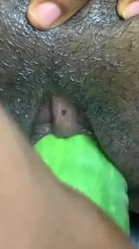 Fată sexy africană cu mască fute un castravete uriaș