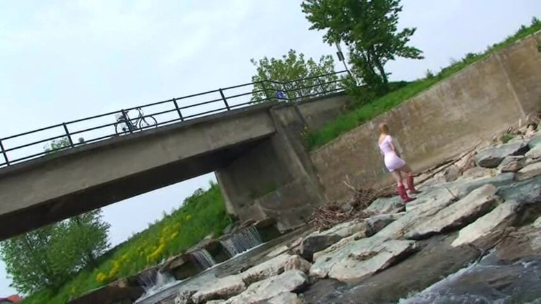 Femdom Austria: Blonde pissing outside in a river