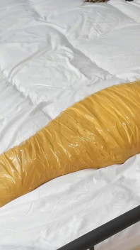 Eine süße barfüßige Freundin benutzt Klebeband, um ihren ganzen Körper zu binden, spielt mit ihren süßen nackten Füßen