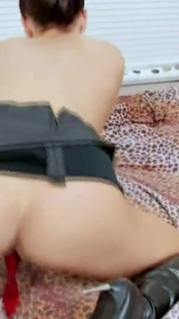 Jonge brunette bevredigt zichzelf met een rode dildo