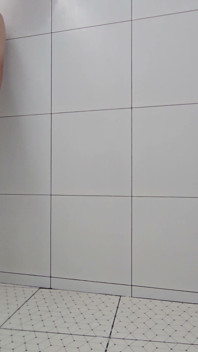 Sissy Kanisa neemt een douche in een witte doucheruimte