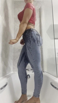 Abdominais posando musculosos, camiseta molhada no chuveiro fumegante