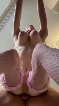 Bellezza snella con grandi calze a rete rosa naturali che stuzzica il sedere succoso da dietro
