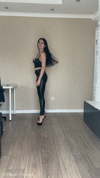 Striptis dengan legging hitam mengkilap, bra kulit, dan sepatu hak tinggi