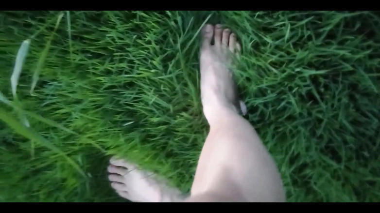 Jon Arteen: Jon Arteen en short court marche sur l’herbe pieds nus,...