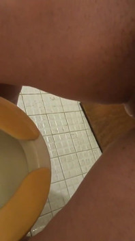 She is pissing standing to the toilet