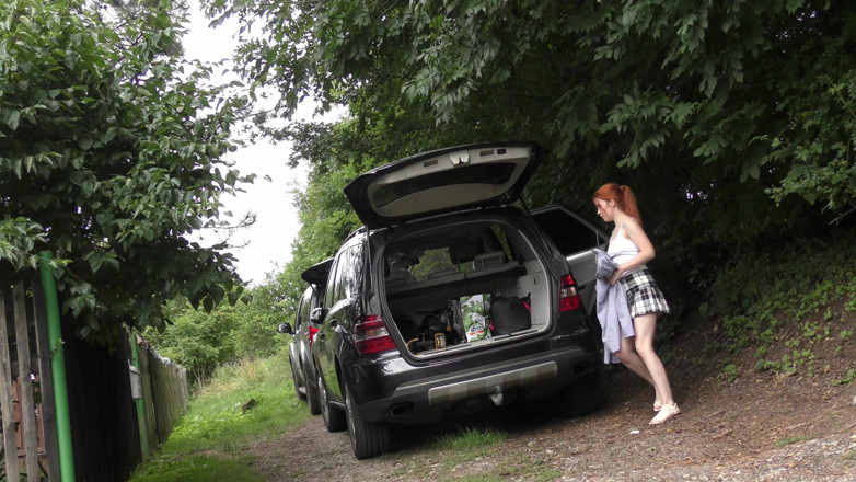 No panties TV: Hot redhead in short skirt loads a car